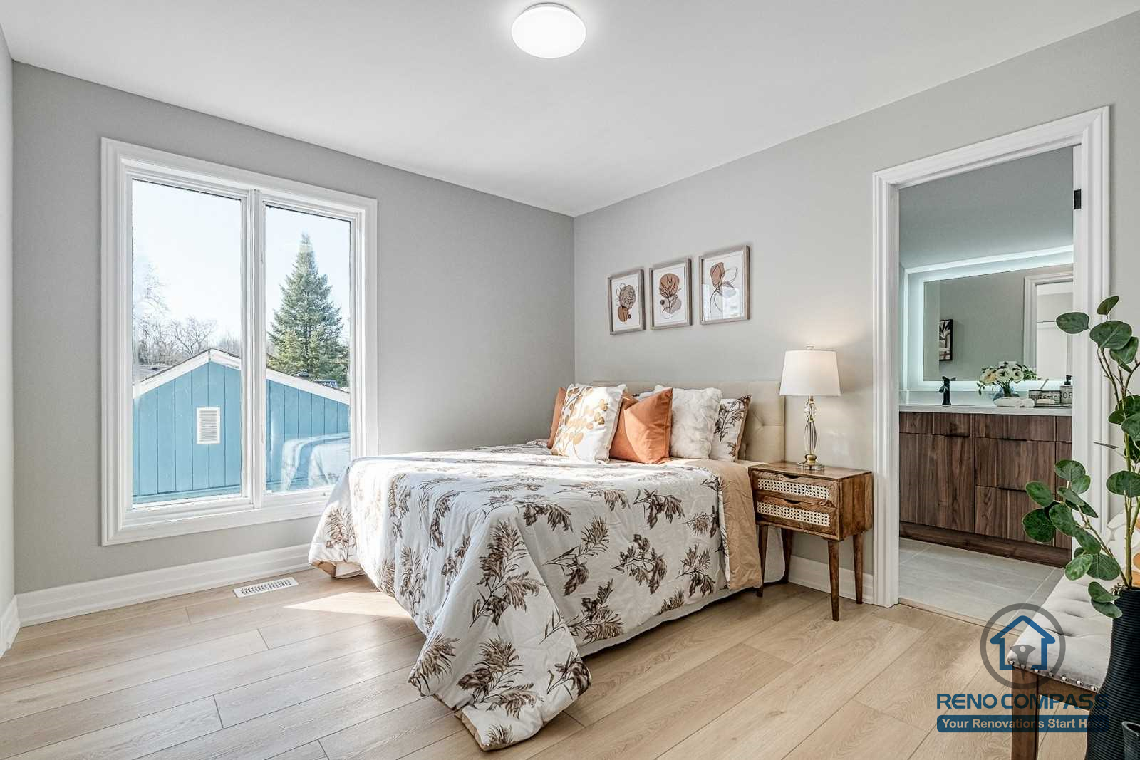 This Georgian interior renovation features a bright primary bedroom with large windows, light wood flooring, and direct access to an ensuite bathroom. The calm layout and cohesive finishes reflect the quality craftsmanship of a Toronto renovation company.