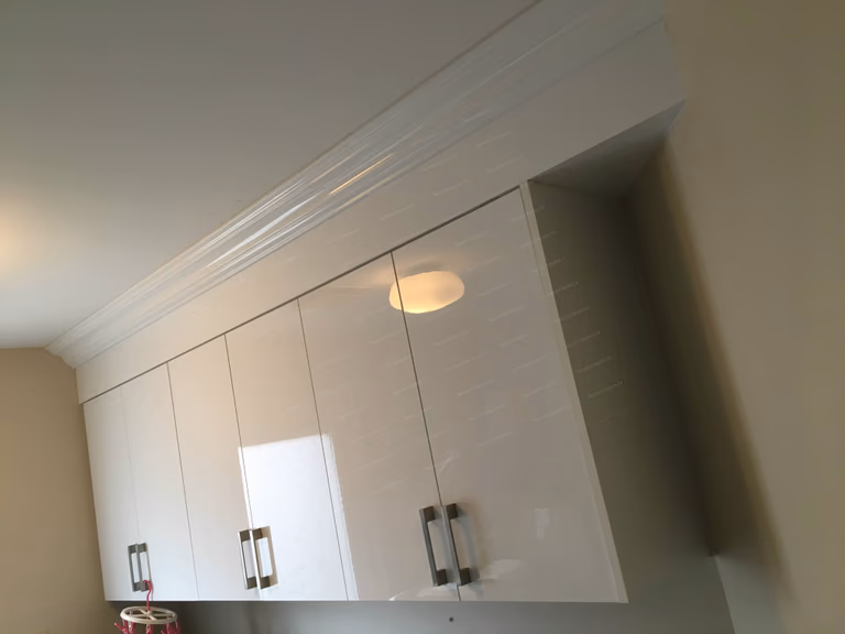 This Oakville interior renovation showcases a clean and functional laundry room upgrade with custom-built white cabinetry, durable stone-style countertops, and optimized storage solutions. The modern cabinet design provides ample space for organization while enhancing the overall brightness and efficiency of the room. Thoughtful layout improvements and quality materials create a practical yet stylish laundry space, reflecting professional craftsmanship and modern interior renovation standards for Oakville homes.