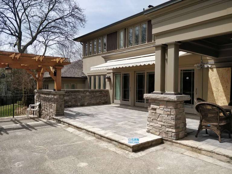 Oakville backyard renovation featuring a spacious interlock stone patio, custom pergola, and stone column detailing. Designed to create a durable, low-maintenance outdoor living and entertaining area.