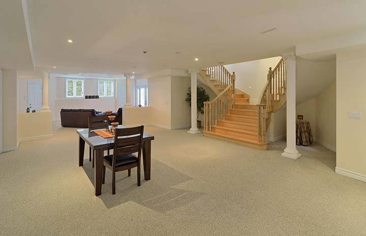 Spacious basement recreation area from a luxury Toronto home renovation featuring an open entertainment space with game table, fitness equipment, and bright walkout access to the backyard. The finished lower level provides a versatile environment for family activities, entertainment, and relaxation. This basement renovation was completed by Reno Compass, a trusted Toronto Renovation Company specializing in luxury home rebuilds and interior renovations across the Greater Toronto Area.