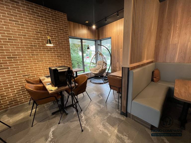 This Mississauga restaurant renovation features a cozy window-side seating and lounge area with warm wood wall finishes, pendant lighting, and natural daylight. The space creates a relaxed dining atmosphere that enhances customer comfort and overall restaurant experience.