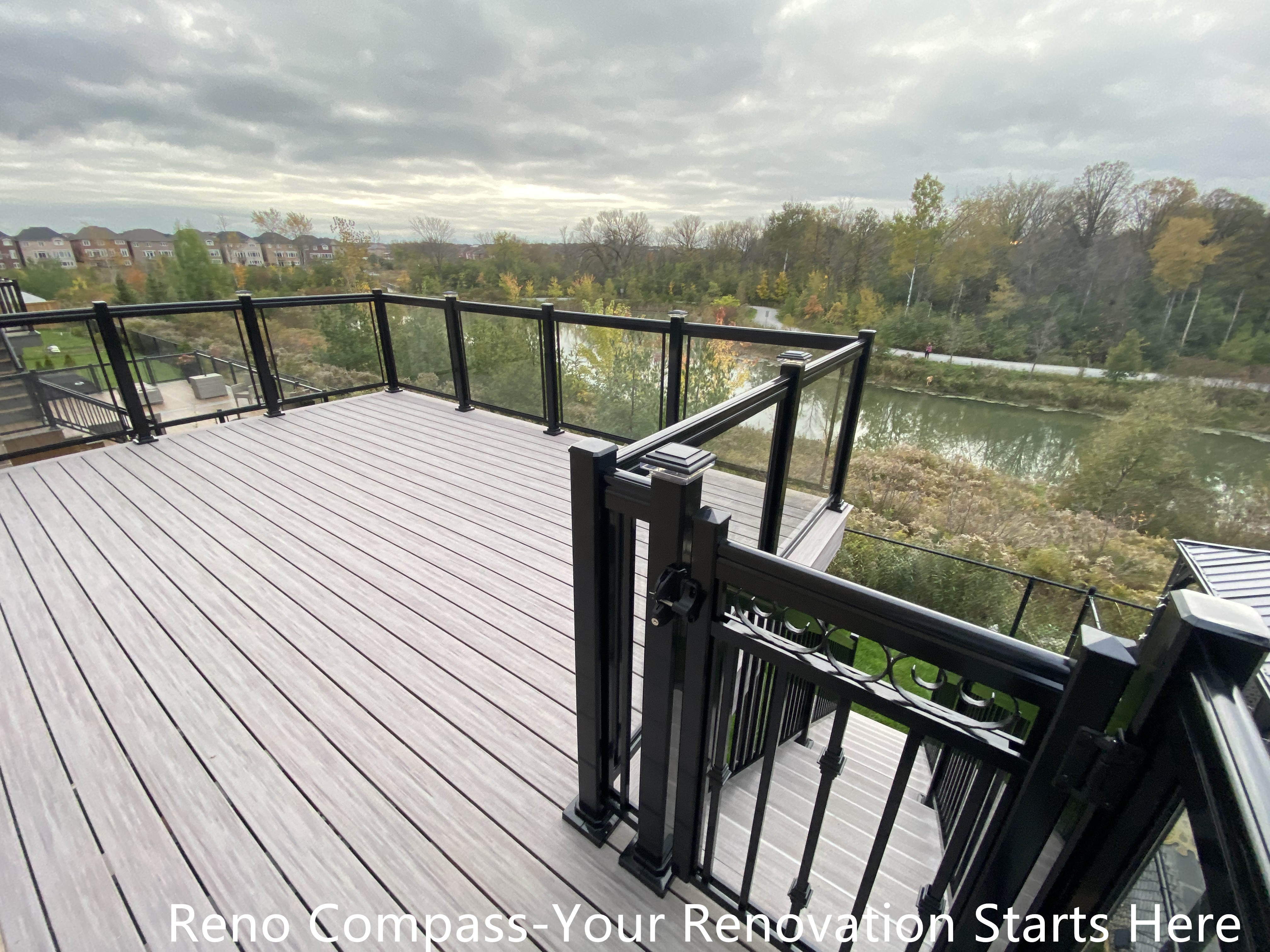 Modern Aurora deck featuring durable wooden flooring and sleek glass railings, designed for outdoor leisure, family gatherings, and seamless integration with the home exterior. Project by Reno Compass Inc.