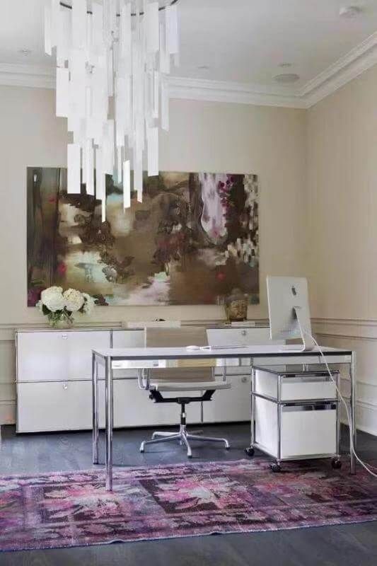 This Toronto interior design project features a refined home office space highlighted by a dramatic statement chandelier and large-scale contemporary artwork. Clean-lined cabinetry and a sleek glass desk create a professional yet inviting environment, while layered lighting enhances depth and dimension. The rich-toned area rug adds warmth and visual contrast against the dark flooring. Designed and completed by Reno Compass Inc., this workspace blends functionality with elevated residential elegance.