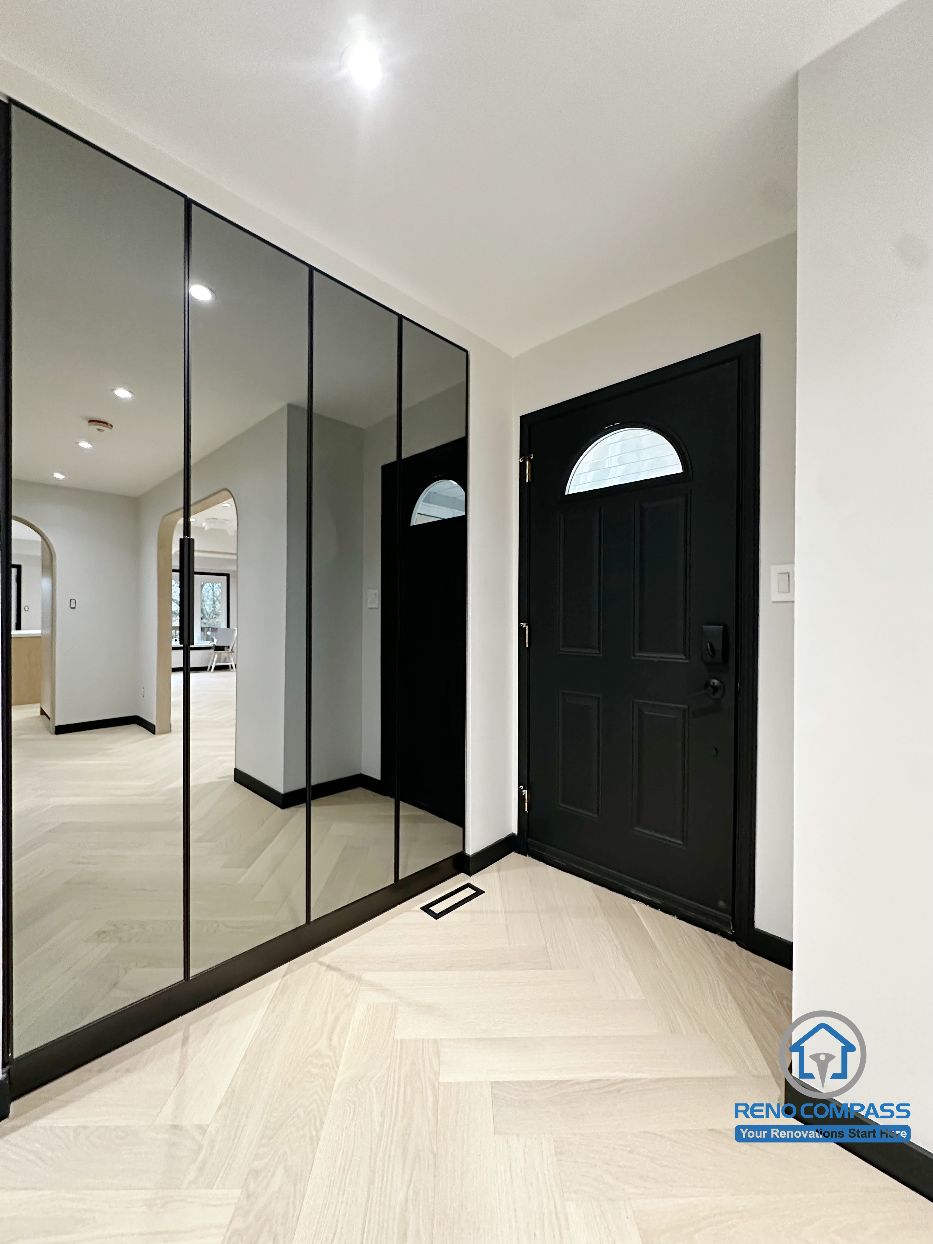 This entryway renovation in Richmond Hill features a full-height mirrored closet, creating a brighter and visually larger entrance space.
The combination of the black front door, clean lines, and herringbone flooring delivers a modern and elegant welcome area with enhanced storage and improved traffic flow.