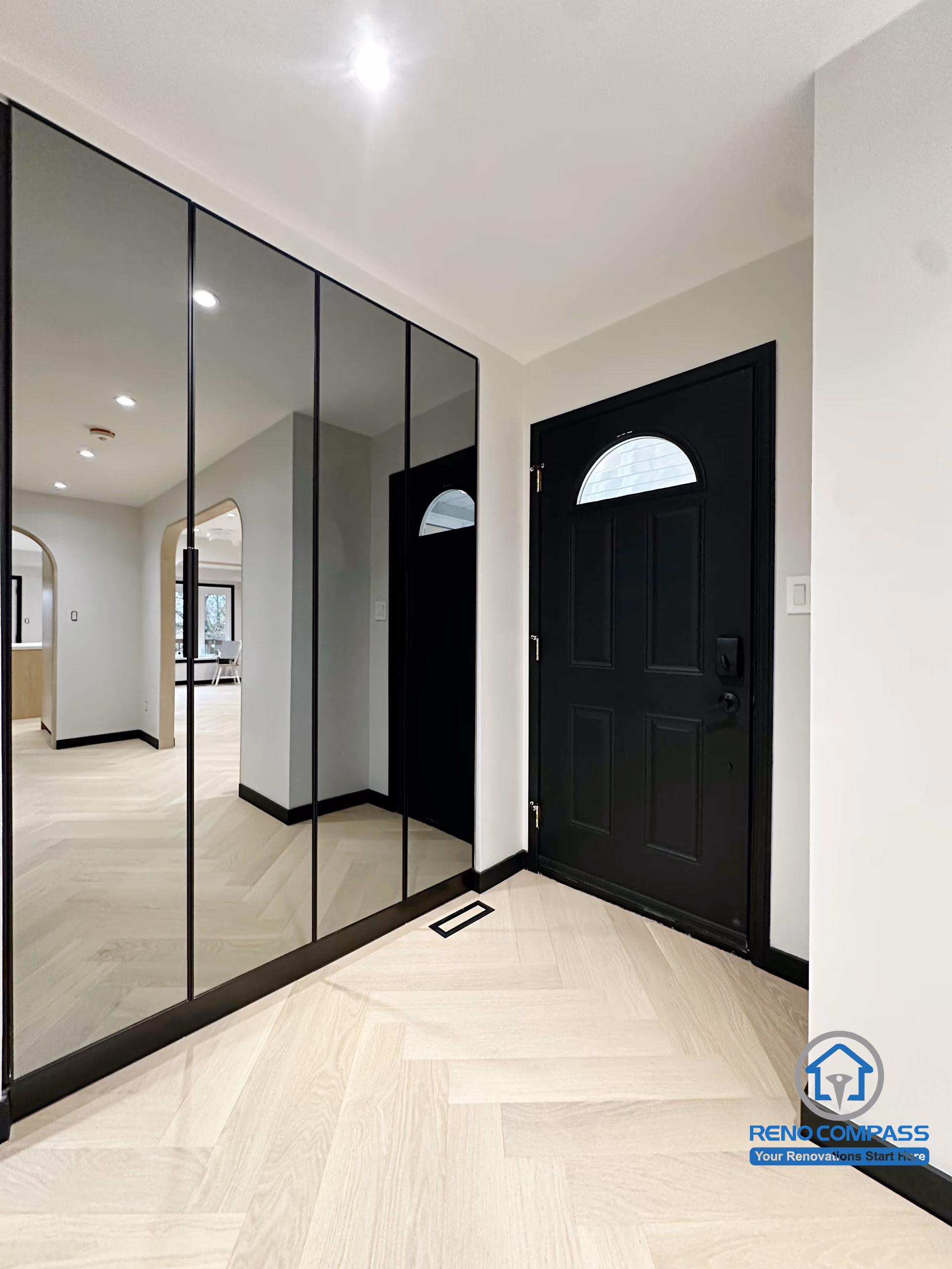 This entryway renovation in Richmond Hill features a full-height mirrored closet, creating a brighter and visually larger entrance space.
The combination of the black front door, clean lines, and herringbone flooring delivers a modern and elegant welcome area with enhanced storage and improved traffic flow.