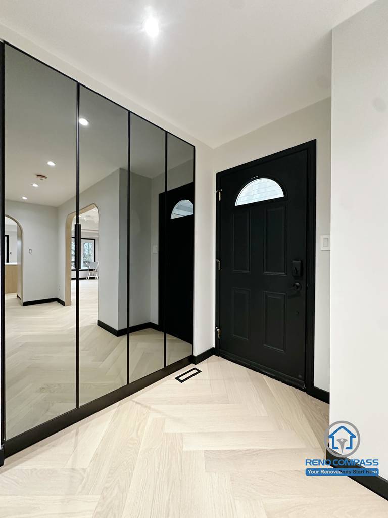 This entryway renovation in Richmond Hill features a full-height mirrored closet, creating a brighter and visually larger entrance space.
The combination of the black front door, clean lines, and herringbone flooring delivers a modern and elegant welcome area with enhanced storage and improved traffic flow.