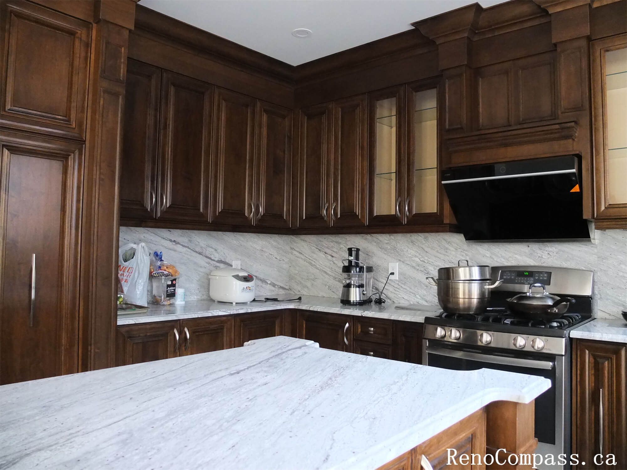 This Richmond Hill interior renovation highlights a beautifully upgraded kitchen featuring custom solid wood cabinetry, marble-style quartz countertops, and a modern cooking area with stainless steel appliances. The L-shaped layout maximizes storage and workspace while maintaining a classic and luxurious design. Detailed cabinet finishes, modern backsplash, and improved lighting enhance both functionality and visual appeal. Completed by a professional Toronto renovation company, this kitchen renovation delivers a timeless and practical space tailored for everyday family use.