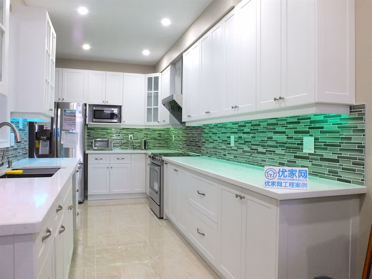 This Vaughan kitchen renovation highlights elegant white shaker cabinets with glass display doors, quartz countertops, and a modern glass mosaic backsplash enhanced by LED under-cabinet lighting. The clean layout and bright finishes create a stylish and functional cooking space. Completed by a trusted Toronto renovation company, the design blends modern aesthetics with everyday practicality.