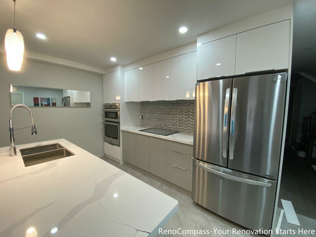 This Mississauga interior renovation showcases a modern open-concept kitchen featuring custom white cabinetry, a large quartz waterfall island, and stainless steel appliances. The upgraded space includes a built-in oven, sleek cooktop, contemporary backsplash, and pendant lighting that enhances both functionality and style. Designed and completed by a professional Toronto renovation company, this kitchen renovation focuses on maximizing storage, improving workflow, and creating a bright, elegant environment for everyday living and entertaining.
