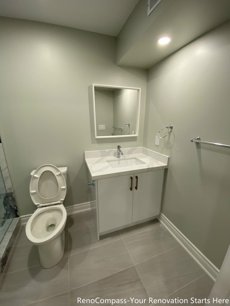 This Richmond Hill basement renovation features a modern bathroom vanity installation with a sleek sink, storage cabinet, and contemporary mirror design. Completed by professional Toronto renovation company Reno Compass Inc., the space is designed for both style and functionality. Clean tile flooring, bright recessed lighting, and efficient layout planning create a comfortable and practical basement bathroom suitable for family living or rental use.