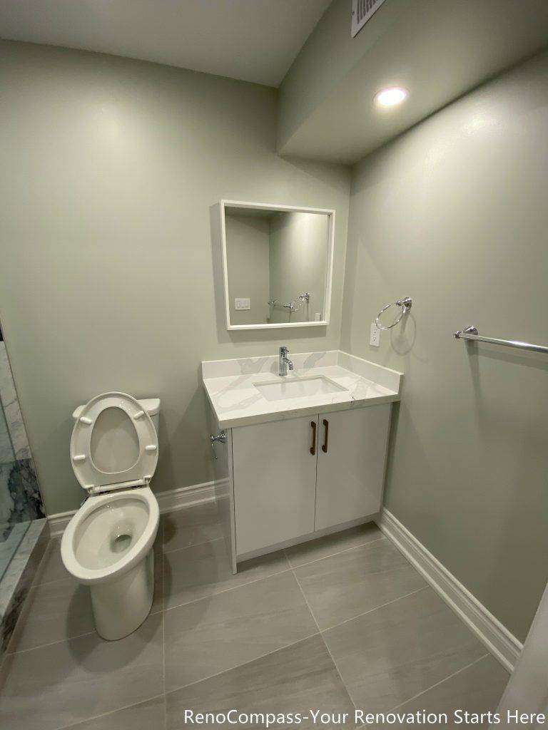 This Richmond Hill basement renovation features a modern bathroom vanity installation with a sleek sink, storage cabinet, and contemporary mirror design. Completed by professional Toronto renovation company Reno Compass Inc., the space is designed for both style and functionality. Clean tile flooring, bright recessed lighting, and efficient layout planning create a comfortable and practical basement bathroom suitable for family living or rental use.