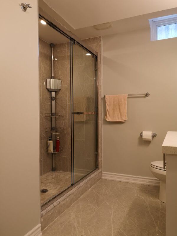 This basement bathroom renovation in Markham features a modern walk-in glass shower with full tile surround, upgraded flooring, and clean neutral finishes. Completed by a professional Toronto renovation company, the project enhances basement comfort and functionality while creating a bright, stylish, and easy-to-maintain bathroom space for everyday use.