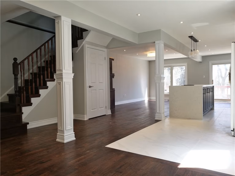 Scarborough whole-house interior renovation featuring an open-concept living and dining area with new hardwood flooring, modern staircase refinishing, and custom column detailing. This project highlights improved layout flow, upgraded lighting, and a bright contemporary interior designed for comfortable family living by a professional Toronto renovation contractor.