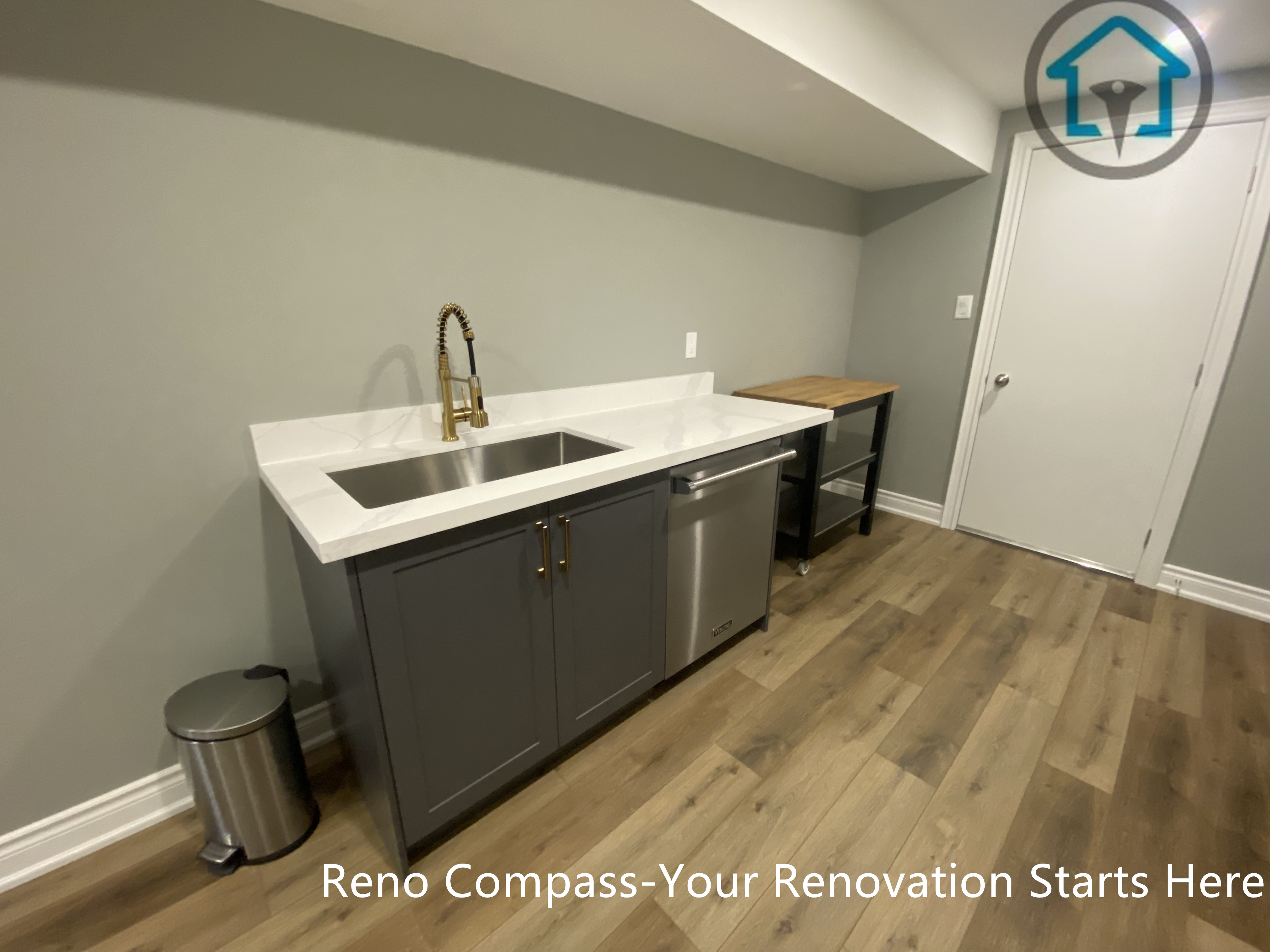 A custom basement wet bar completed as part of a Vaughan basement renovation. This kitchenette area features quartz countertops, an undermount sink, stainless steel dishwasher, custom cabinetry, and durable wood-look flooring, designed to support everyday use and entertainment needs. Designed and built by Reno Compass, the space enhances functionality while maintaining a clean and cohesive basement layout for homes in Vaughan and the Greater Toronto Area.