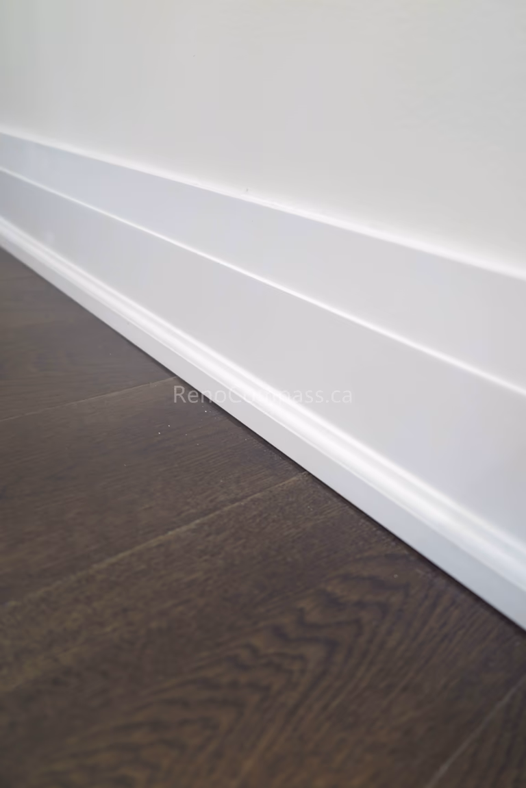 This Toronto interior renovation highlights clean white modern baseboard installation paired with premium dark hardwood flooring. The precise trim work and seamless finishing enhance the home’s contemporary style while adding durability and value. Completed by a professional Toronto renovation contractor, this detail reflects Reno Compass Inc.’s commitment to quality craftsmanship and refined interior finishing.