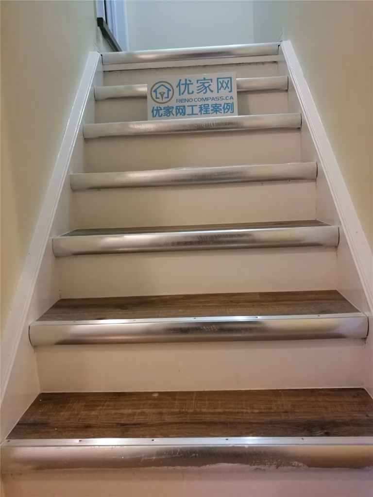 This Markham basement renovation features newly installed dark hardwood flooring and a refreshed staircase area, creating a clean, modern, and durable lower-level living space. Completed by Reno Compass Inc., the project enhances both functionality and visual appeal for everyday comfort.