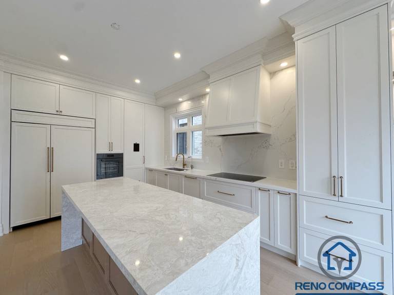 Modern Toronto kitchen with a large island, natural light from windows and patio doors, and an open layout that enhances functionality and spacious living.