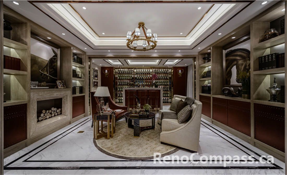 This Toronto interior renovation features a bespoke home bar design with a marble countertop, custom wood cabinetry, and a full-height illuminated wine and liquor display wall. Elegant ceiling lighting, brass accents, and tailored seating create a refined entertainment space perfect for hosting guests. Completed by an experienced Toronto Renovation Company, the project highlights premium finishes, functional layout planning, and sophisticated craftsmanship, delivering a private luxury bar experience within a modern residential setting.c