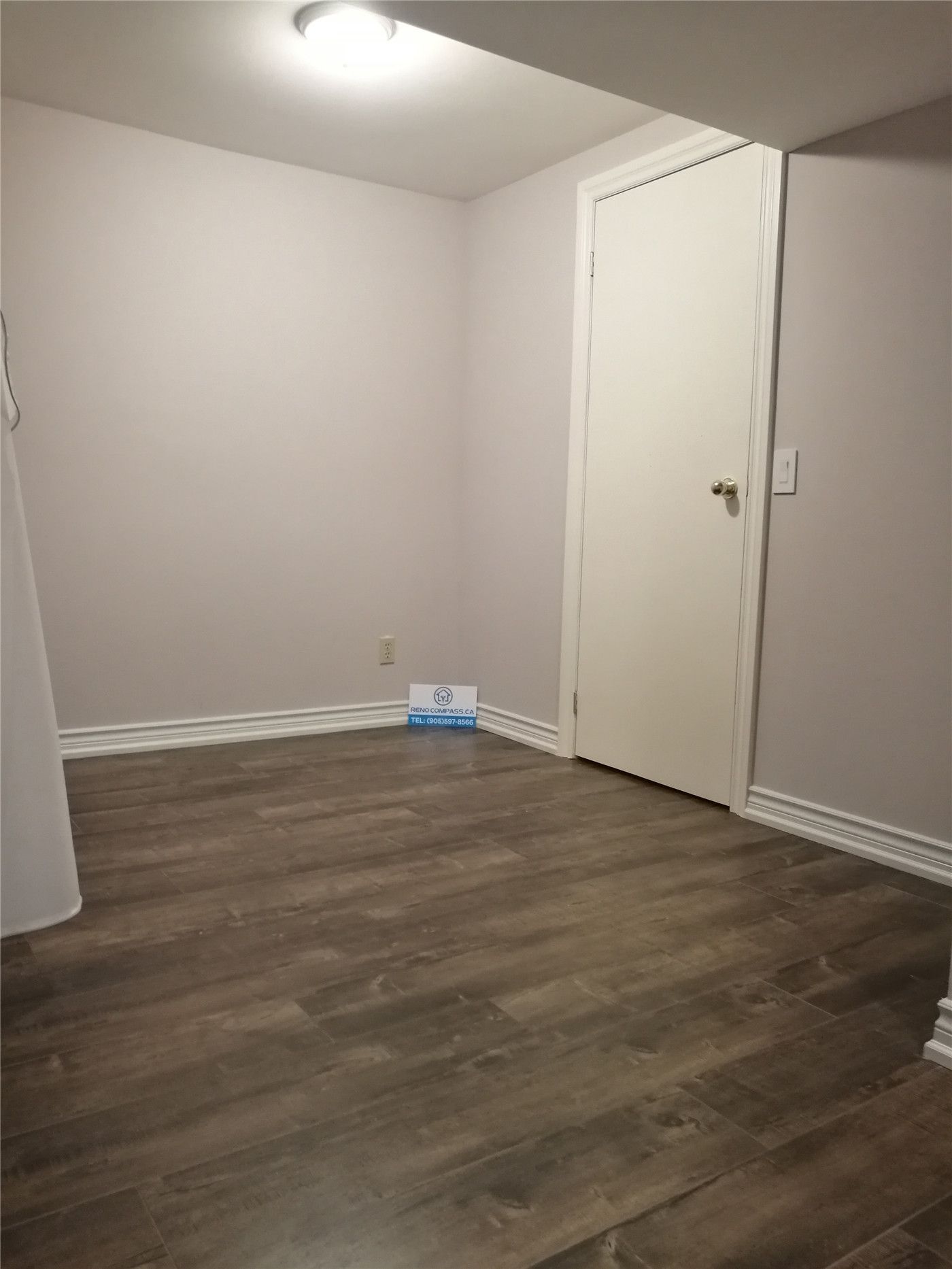This image shows a completed basement renovation project in Markham, featuring newly installed wood-look flooring, fresh white walls, and a clean, functional layout. The finished basement offers a bright, modern feel and can be used as a family room, home office, or multipurpose living space. Renovation completed by a professional Toronto renovation company with a focus on durability, comfort, and practical design.
