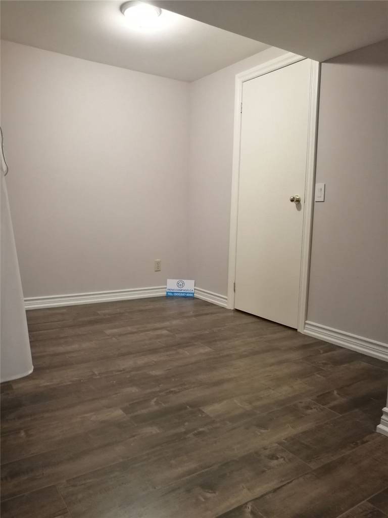This image shows a completed basement renovation project in Markham, featuring newly installed wood-look flooring, fresh white walls, and a clean, functional layout. The finished basement offers a bright, modern feel and can be used as a family room, home office, or multipurpose living space. Renovation completed by a professional Toronto renovation company with a focus on durability, comfort, and practical design.