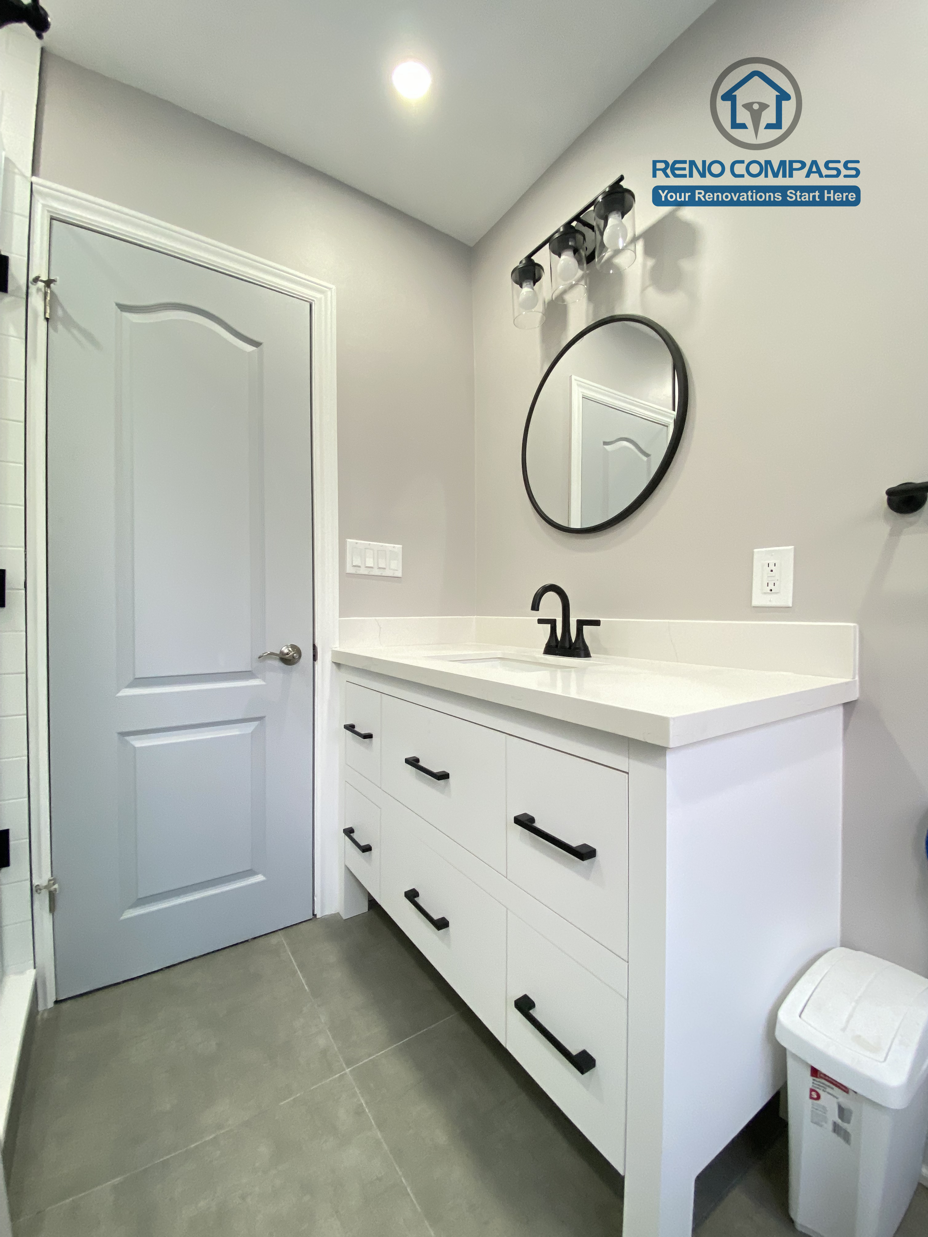 This North York bathroom renovation features a modern white vanity with a quartz countertop, matte black hardware, and a clean, functional layout. The neutral wall color, large-format floor tiles, and integrated lighting create a bright and timeless bathroom design, completed by a Toronto renovation company focused on quality craftsmanship and everyday usability