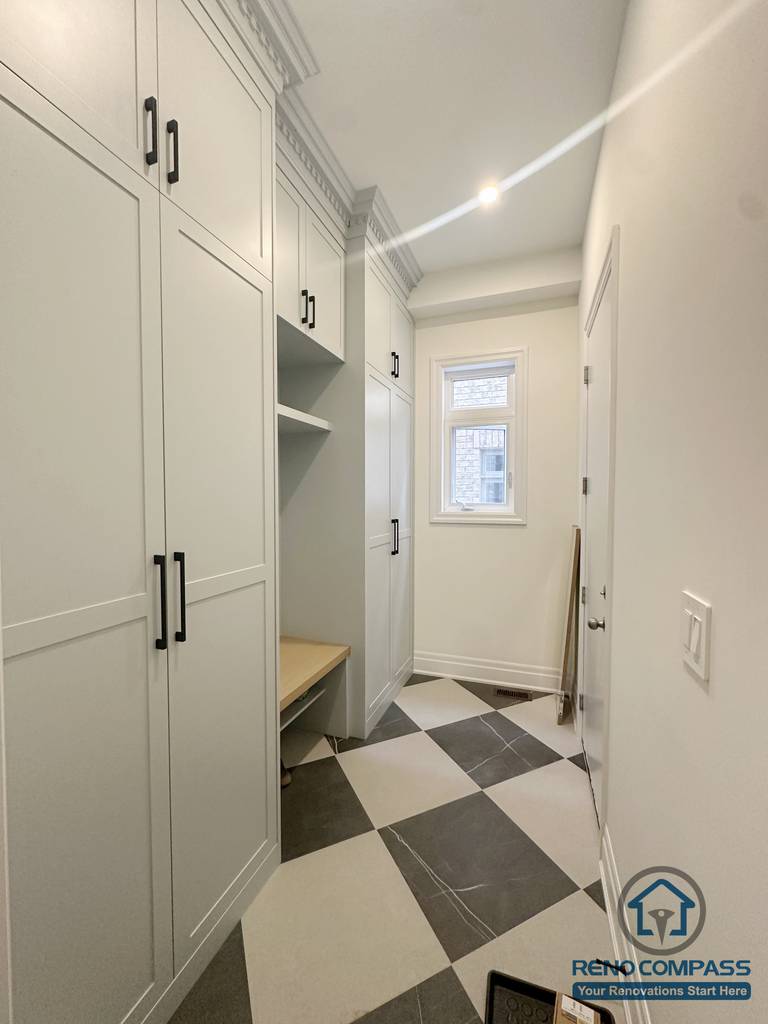 Narrow mud room layout in a Toronto home upgrade featuring built-in cabinets, bench seating, and tiled flooring for efficient entryway organization.