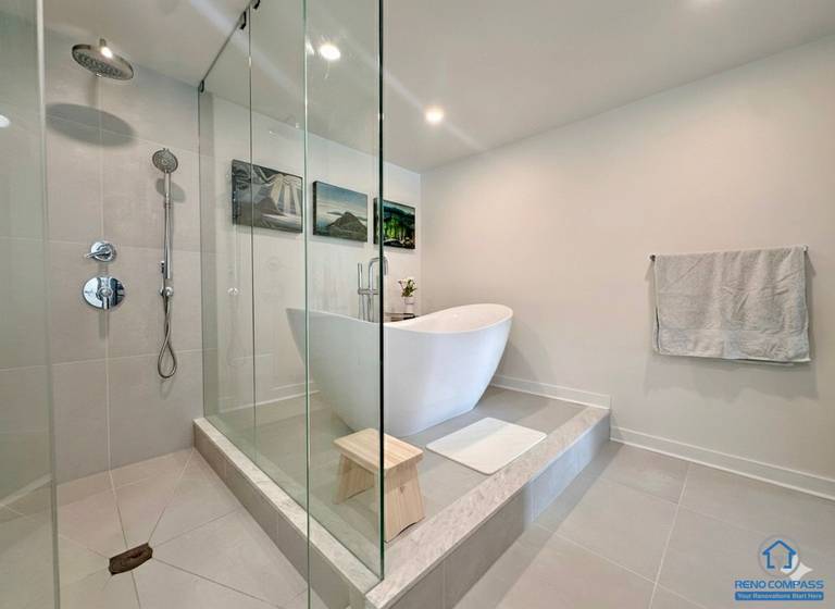 A luxury bathroom renovation in Toronto showcasing a frameless glass shower, freestanding soaking tub, and modern tile finishes. This spa-inspired design offers a clean, elegant, and relaxing atmosphere with improved layout and lighting.