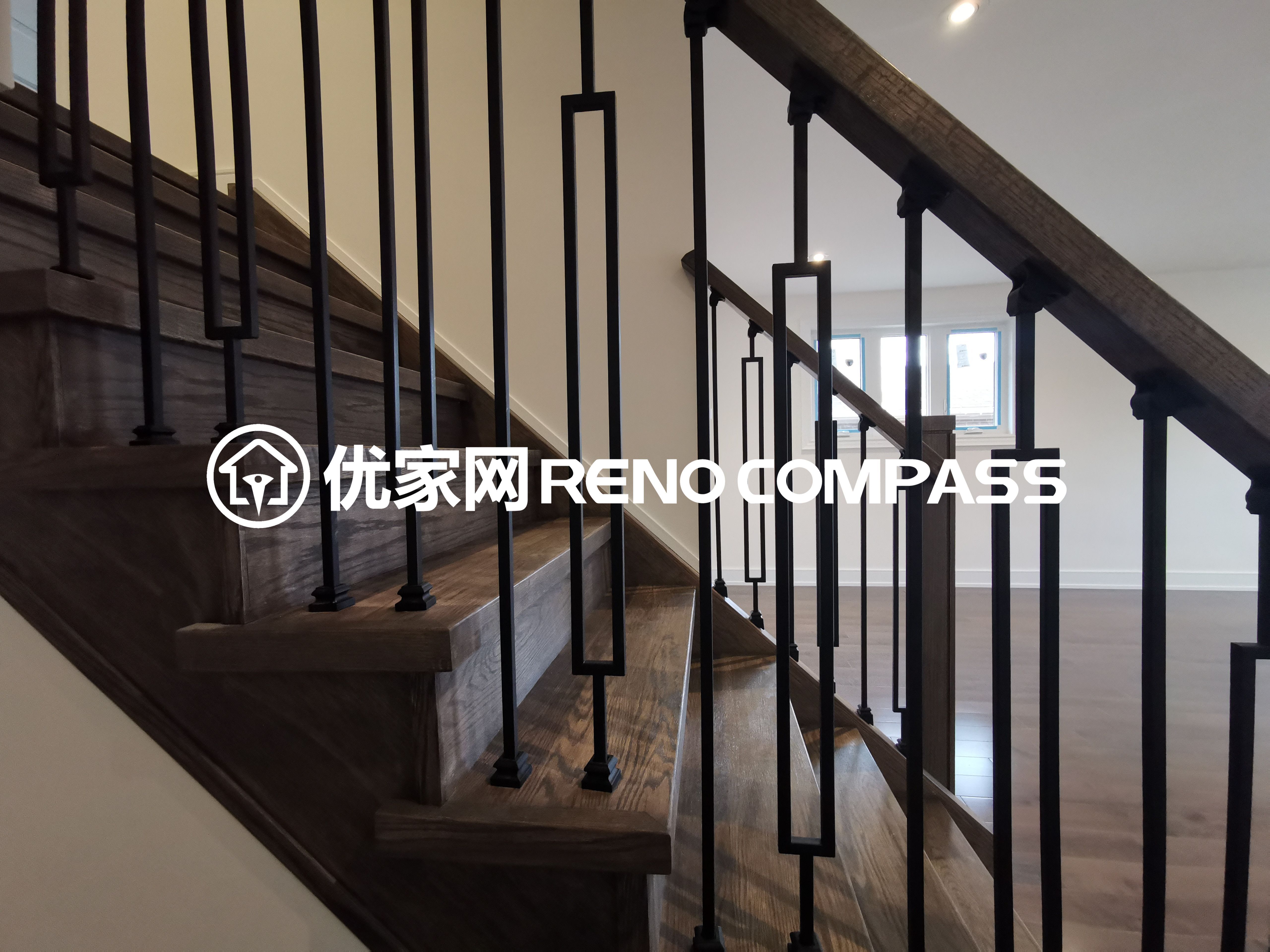 This image highlights a modern staircase completed as part of a North York interior renovation project. The staircase features natural wood treads paired with sleek black metal railings, creating a clean and contemporary contrast. The minimalist railing design enhances visual openness while maintaining safety and durability. Seamlessly integrated with the surrounding hardwood flooring, this staircase design reflects precise craftsmanship and thoughtful material selection, adding both architectural character and functional value to the overall interior renovation.
