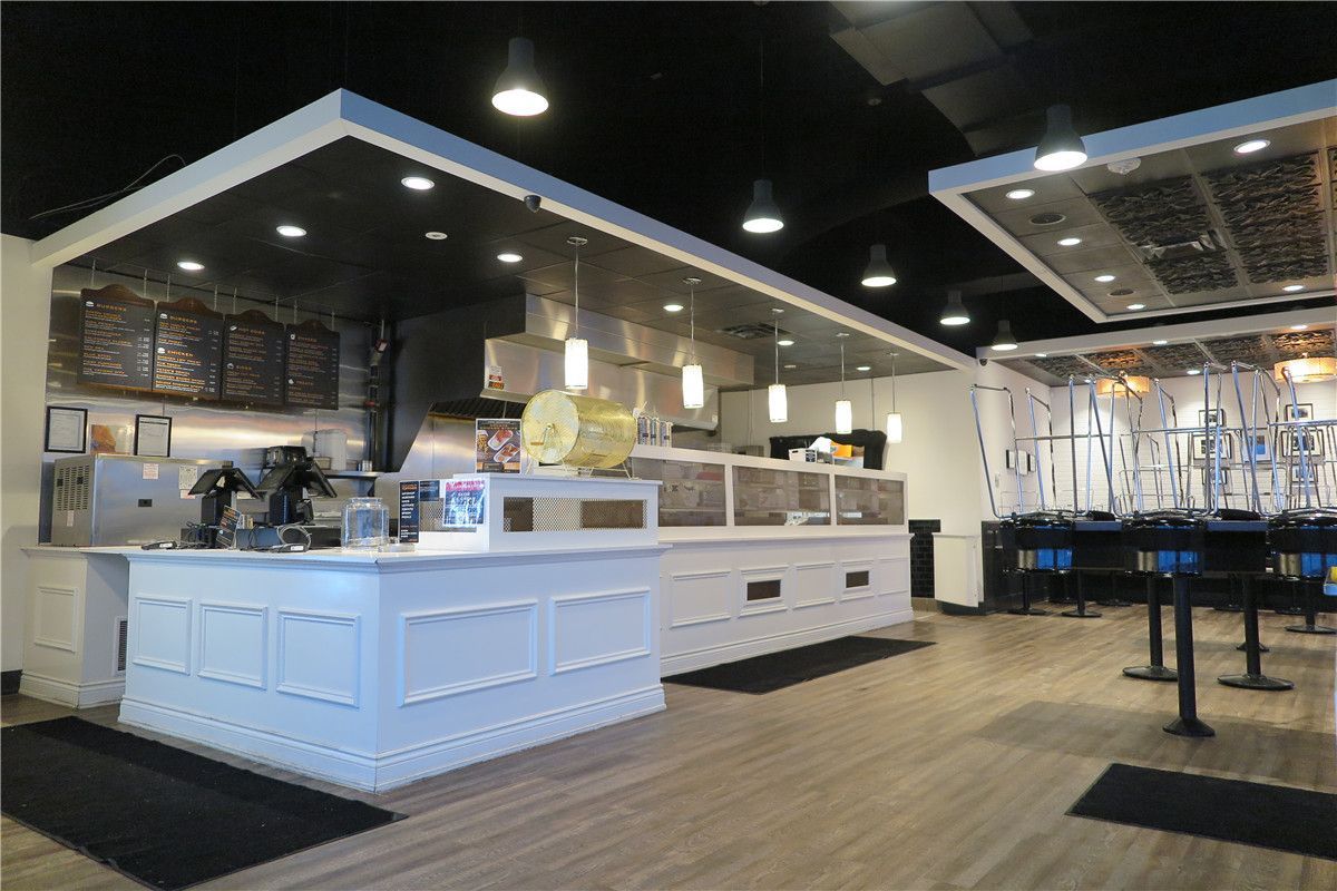 This Toronto restaurant renovation highlights the upgraded front service counter and customer-facing area completed by Reno Compass Inc. The project included custom-built cashier counters, integrated POS stations, decorative ceiling bulkheads with recessed lighting, and commercial-grade pendant fixtures to enhance ambiance and visibility.

The open layout improves customer flow and ordering efficiency, while durable vinyl flooring ensures long-term performance in high-traffic commercial environments. The refined white counter millwork contrasts with the modern dark ceiling design, creating a clean yet contemporary restaurant atmosphere.

As an experienced Toronto renovation company, Reno Compass Inc. specializes in restaurant interior renovations that balance operational functionality with strong visual branding.