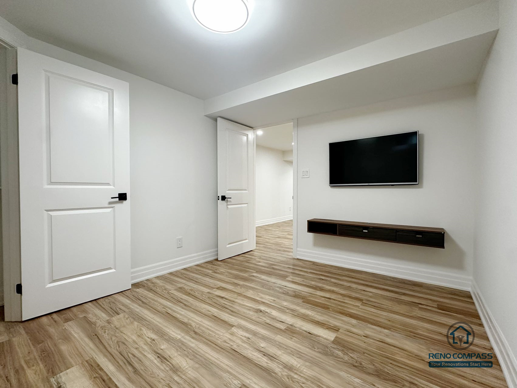 his image features a finished basement flex room in a Pickering renovation project, designed to support multiple uses such as a guest room, home office, or media space. The room includes durable flooring, clean wall finishes, and integrated lighting to ensure everyday comfort and functionality. A wall-mounted media unit provides a practical focal point without occupying floor space, while clear door access allows smooth circulation to adjacent basement areas. The neutral design and simple layout make this room adaptable to changing household needs over time.
Location: Pickering · Toronto Contractor: Reno Compass