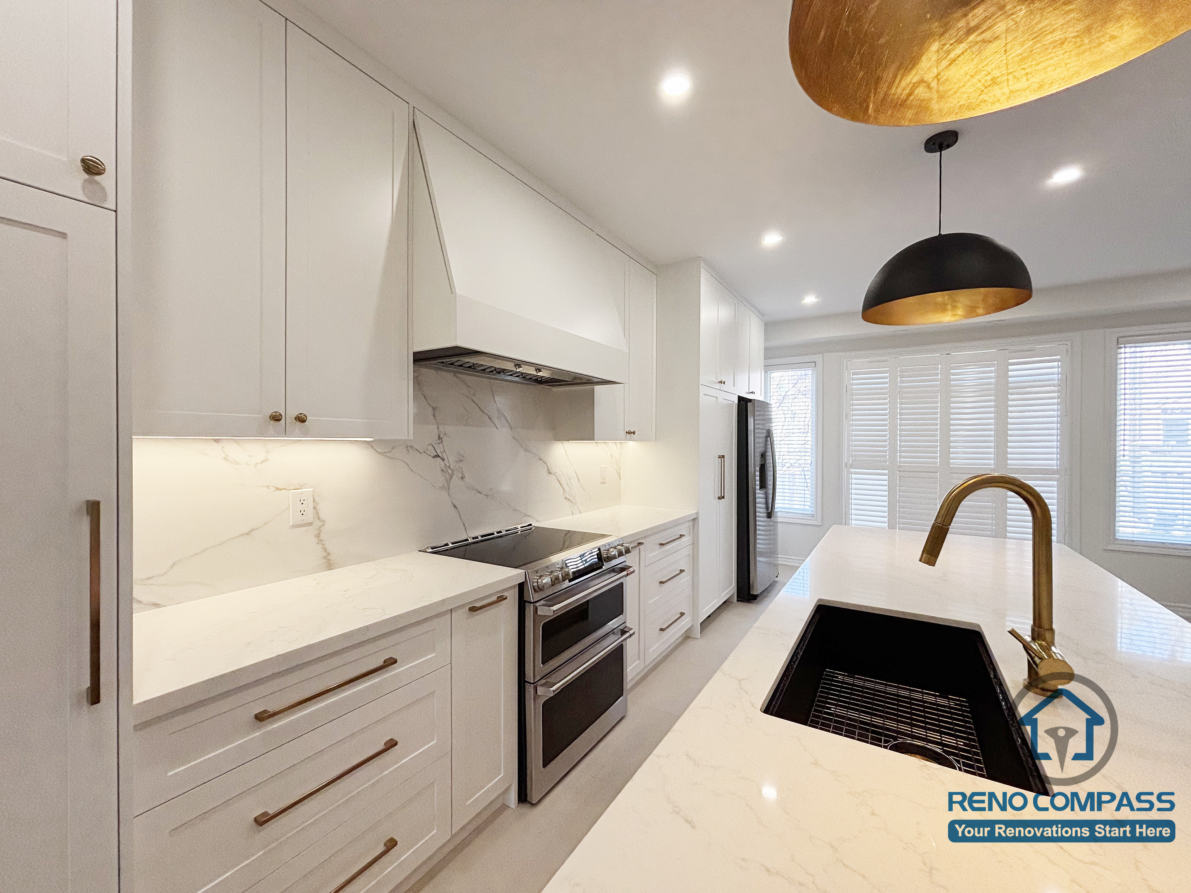 This Oakville kitchen renovation highlights the relationship between the main cooking zone and the island sink, creating a practical and efficient workspace for everyday use. The continuous backsplash, built-in hood, and clean-lined cabinetry establish a cohesive cooking area, while the island supports preparation and cleanup without interrupting circulation. Balanced lighting and durable surfaces reinforce a calm, functional kitchen environment. Completed by Reno Compass, this design reflects a well-considered approach to modern Oakville kitchen renovation focused on long-term usability.