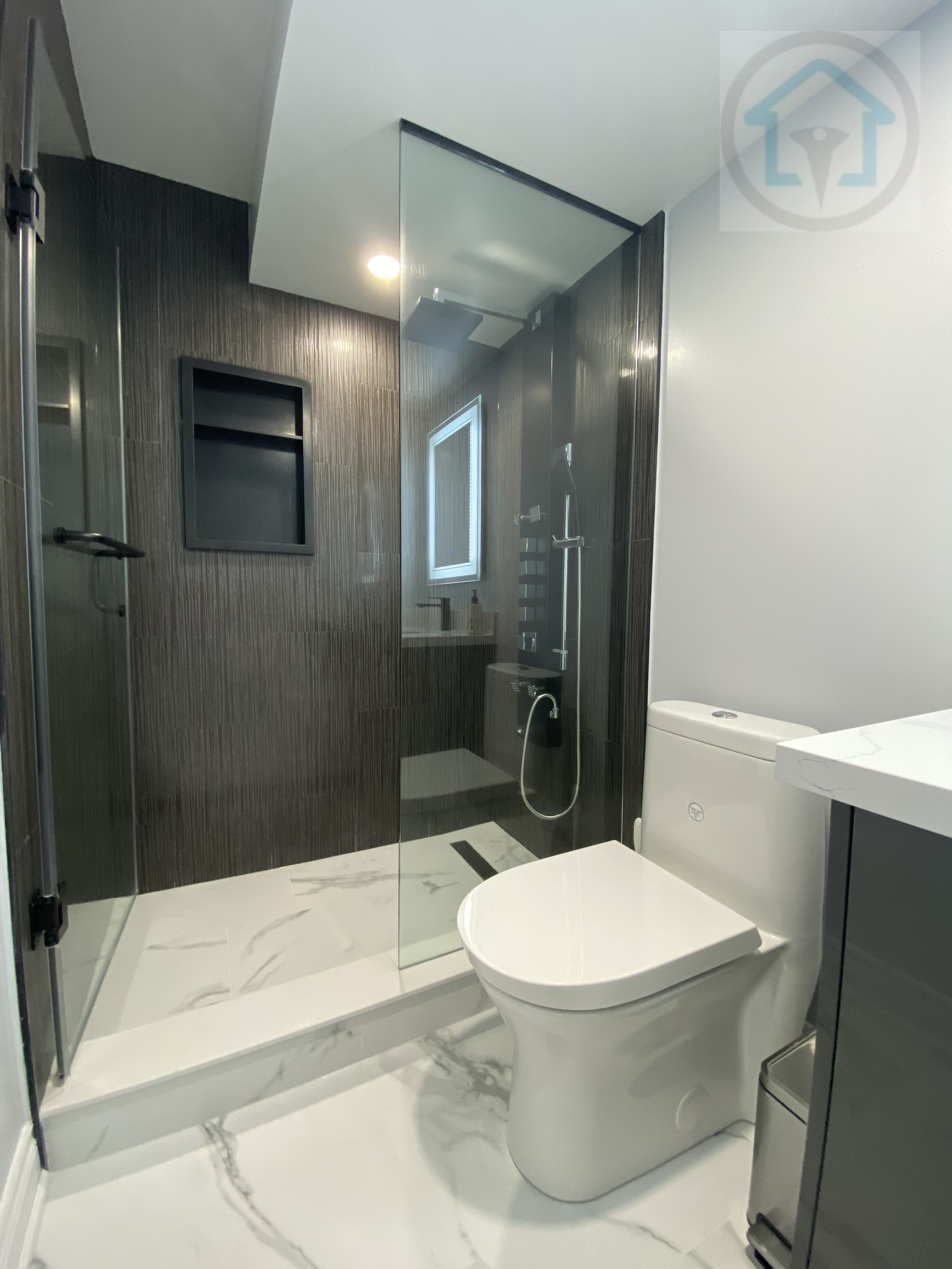 This Vaughan basement renovation features a modern bathroom with a glass-enclosed shower, large-format wall tiles, and clean-lined fixtures. The layout prioritizes functionality and ease of maintenance, while neutral finishes and efficient lighting create a bright, practical basement bathroom suitable for everyday use.