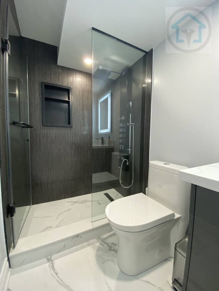 This Vaughan basement renovation features a modern bathroom with a glass-enclosed shower, large-format wall tiles, and clean-lined fixtures. The layout prioritizes functionality and ease of maintenance, while neutral finishes and efficient lighting create a bright, practical basement bathroom suitable for everyday use.