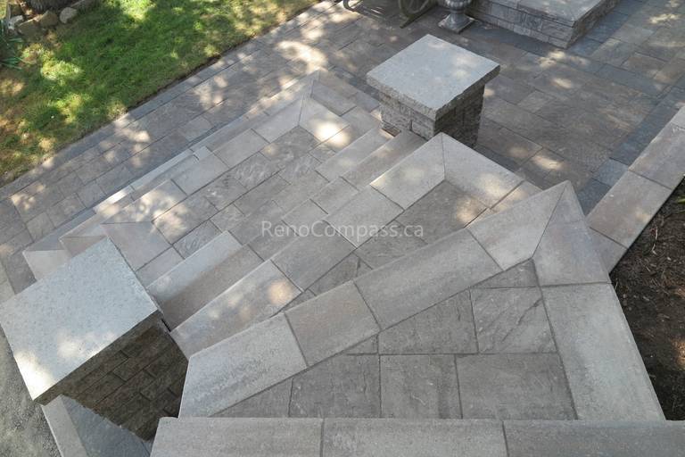 This Mississauga landscaping renovation showcases custom interlocking front entrance steps and landing patio designed for both visual impact and functionality. The multi-level stone layout creates a smooth transition from driveway to entrance while enhancing safety and flow. Premium interlocking pavers and stone columns add depth, structure, and a refined architectural feel to the exterior. Completed by Reno Compass Inc., this project highlights expert craftsmanship in residential interlocking and front yard landscaping design.