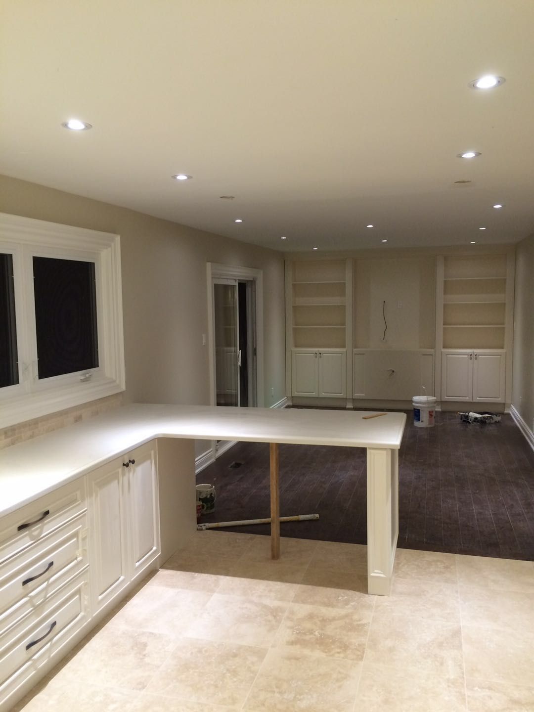 This Toronto interior renovation project showcases a custom cabinetry and countertop installation designed to enhance storage, functionality, and modern interior flow. The newly installed white cabinetry and extended countertop create a clean and practical workspace that connects seamlessly with the open-concept living area.

The L-shaped counter design maximizes usable surface space for meal preparation and daily use, while built-in storage drawers and cabinets provide organized, efficient storage. Recessed pot lights brighten the entire space, highlighting the neutral finishes and creating a warm, inviting environment.

Completed by a professional Toronto renovation company, this interior upgrade reflects quality craftsmanship, thoughtful space planning, and a modern aesthetic that improves both visual appeal and everyday usability for homeowners.