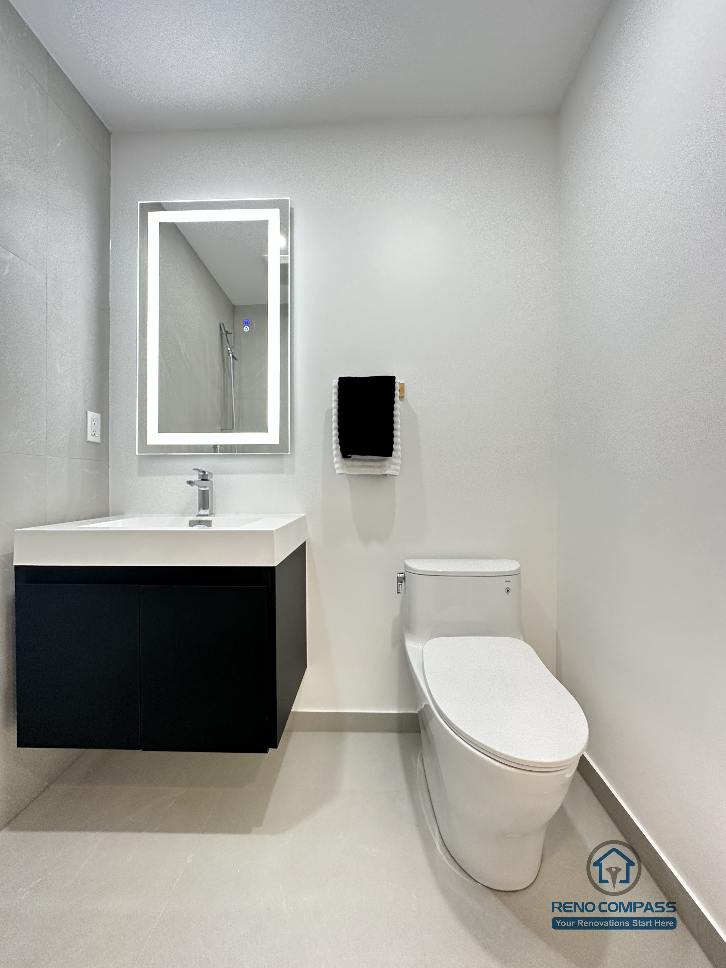 This image features a clean and modern accessible bathroom layout in Brampton, highlighting a floating vanity, integrated LED mirror, and a compact toilet designed for efficient space use. The wall-mounted vanity improves floor clearance, making the bathroom easier to clean and more accessible for daily use and pet care. Neutral-toned tiles and minimal fixtures create a calm, functional environment suitable for barrier-free living. This thoughtfully planned bathroom renovation was completed by an experienced Toronto Renovation Company specializing in accessible and pet-friendly home solutions.