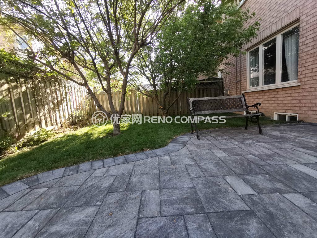 Elegant backyard in Richmond Hill featuring a custom interlocking patio design with a shaded seating area and lush greenery.
