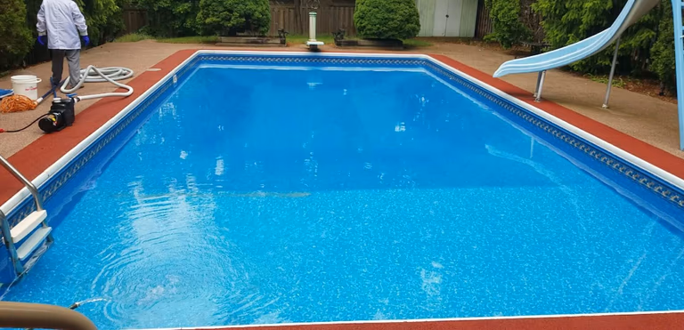 After renovation photo of a fully restored backyard swimming pool in Toronto. The new bright blue liner, clean water, and resurfaced edges highlight the professional pool transformation from old and damaged to modern and inviting. Expert pool renovation by local Toronto specialists.