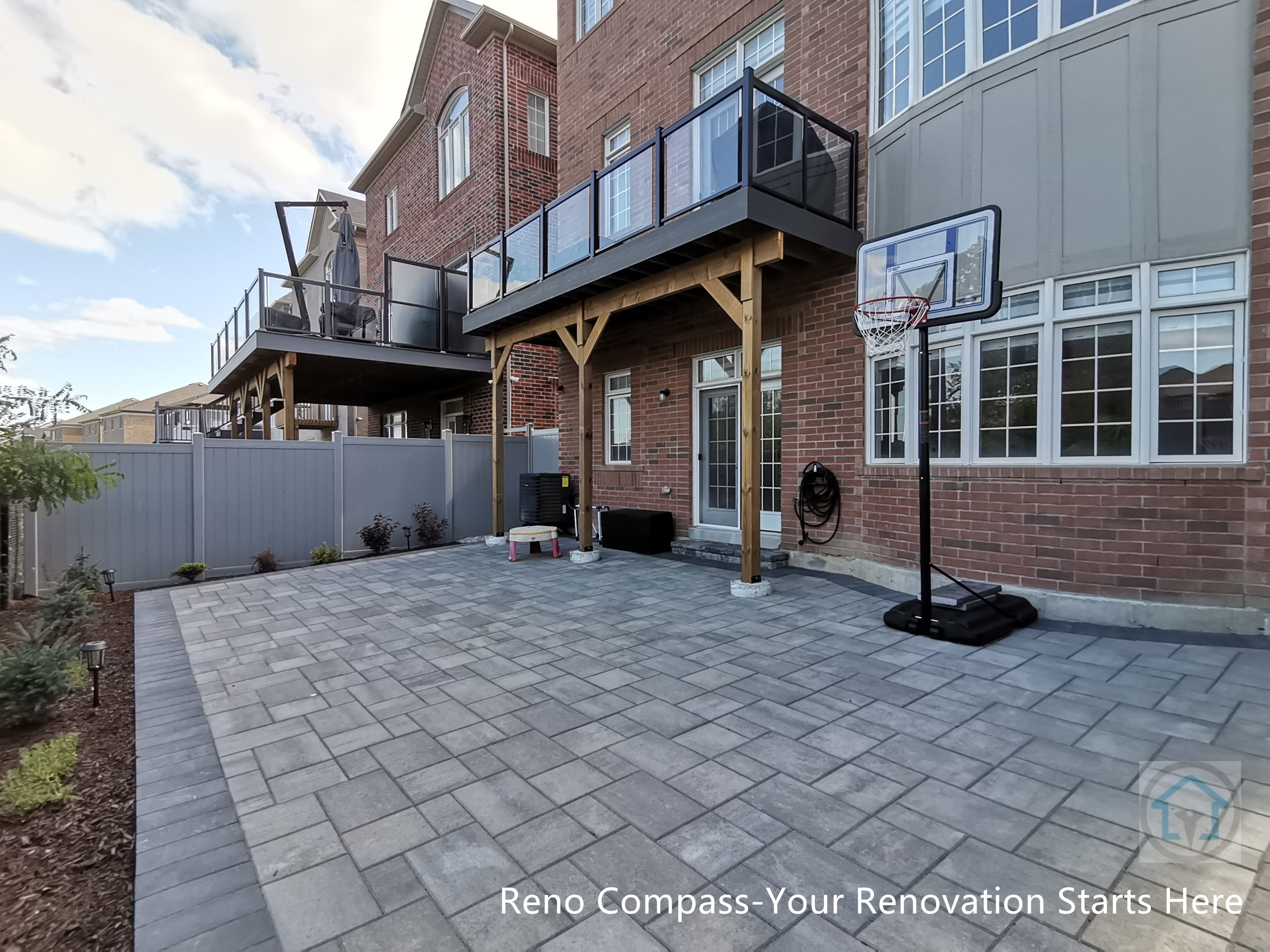 This Vaughan backyard renovation combines a covered wood deck structure with a spacious interlocking stone patio. The elevated deck provides shaded outdoor living space, while the durable paver surface below supports everyday use, play, and entertaining. The design creates a functional, low-maintenance backyard that integrates seamlessly with the home’s architecture.