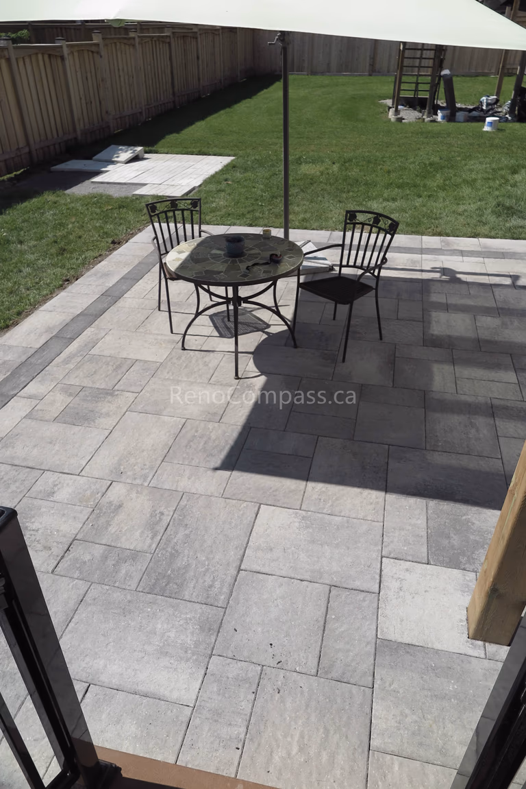 This backyard landscaping project in Markham highlights a spacious interlocking stone patio designed for comfortable outdoor dining and relaxation. The neutral-toned pavers with contrasting borders create a clean and modern layout that complements the surrounding lawn and fencing. Built for durability and low maintenance, the patio provides a functional extension of the home’s living space. Completed by an experienced Toronto renovation company, this outdoor upgrade enhances both visual appeal and everyday usability for homeowners.