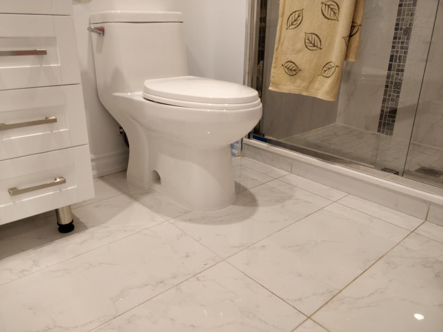 This Scarborough basement renovation includes a newly built bathroom featuring a clean white vanity cabinet, modern sink, toilet, and glass shower enclosure. The bright lighting and neutral finishes create a fresh and functional bathroom space, adding comfort and value to the basement living area by a professional Toronto renovation company.