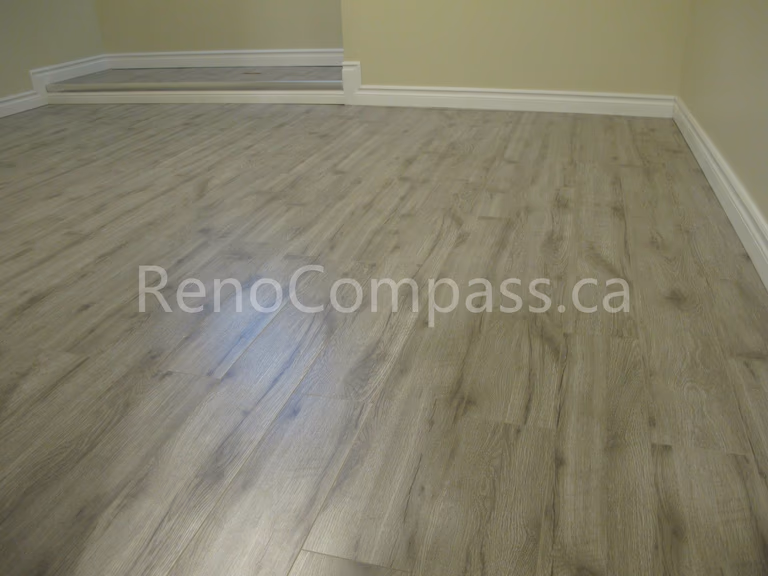 New waterproof vinyl flooring installed in this Markham basement renovation project, featuring durable wood-look planks and clean modern baseboards. Completed by Reno Compass, this basement upgrade enhances comfort, moisture resistance, and contemporary interior style for a functional finished living space.