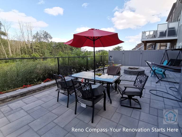 This Vaughan backyard interlocking patio features a spacious stone paver layout designed for outdoor dining and relaxation. The clean paving pattern supports patio furniture and daily use, while the open layout connects seamlessly with the deck structure and fencing, creating a comfortable and functional outdoor living space.