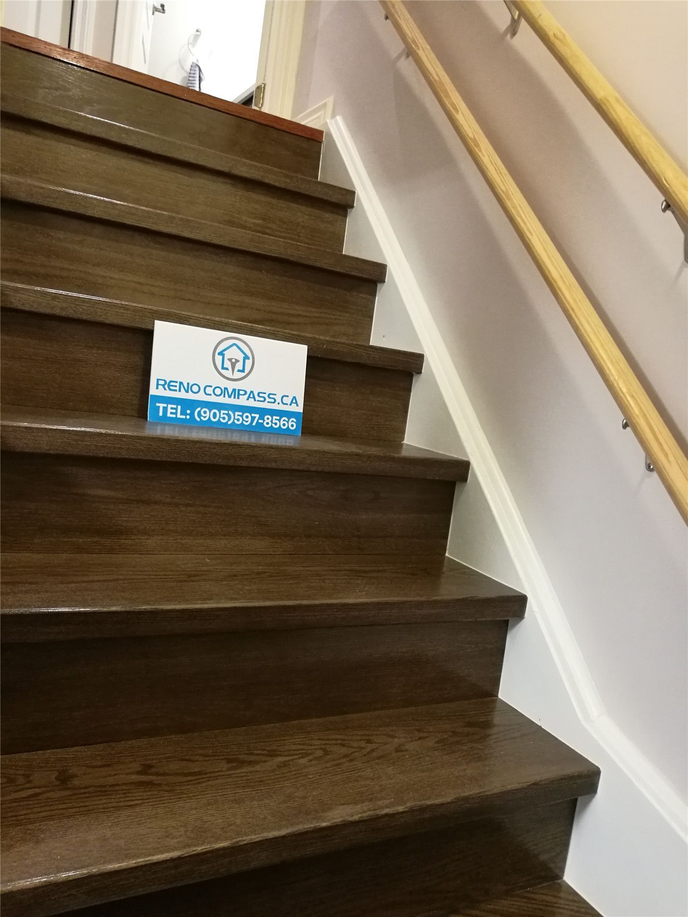 This image features a finished staircase as part of a Markham basement renovation project. The staircase includes dark hardwood stair treads, clean white stringers, and a modern handrail system, creating a safe and visually cohesive transition between floors. The updated staircase design aligns with the basement flooring and overall interior finishes, enhancing both functionality and aesthetics. This upgrade reflects the attention to detail and craftsmanship delivered by a professional Toronto Renovation Company.