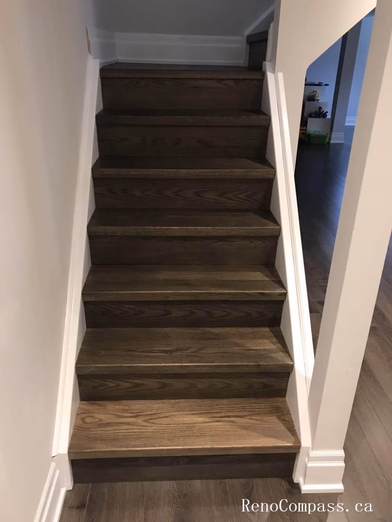 Richmond Hill basement renovation showcasing newly finished staircase with dark wood steps, upgraded baseboards, and clean modern trim work. This basement upgrade enhances safety, durability, and visual continuity, creating a seamless transition between floors with high-quality craftsmanship and contemporary design.