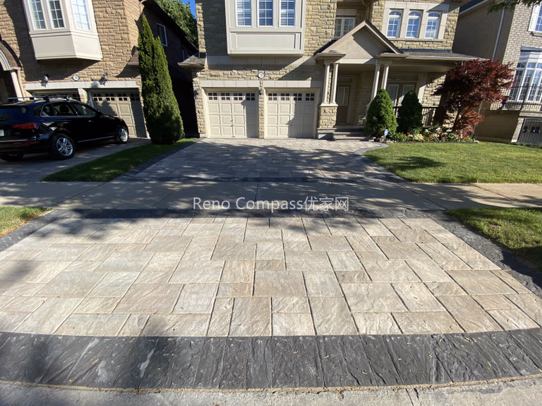 This image showcases a completed driveway interlocking project in North York, featuring natural stone pavers with a structured layout and clean border detailing. The interlocking driveway is designed to provide long-term durability, proper drainage, and a refined curb appeal that complements the home’s stone façade. Precise alignment and material selection ensure a balanced appearance while supporting daily vehicle use. Completed by a Toronto landscaping and interlocking contractor, this North York driveway renovation highlights quality craftsmanship, structural stability, and a practical approach to residential outdoor paving.
