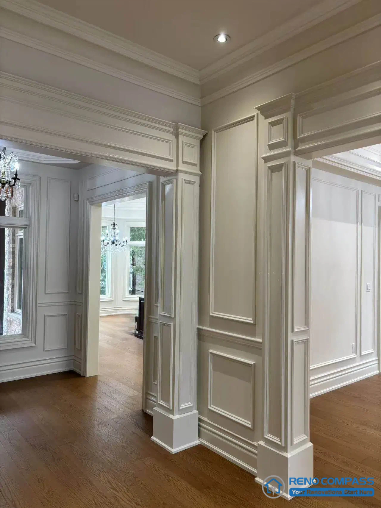 This image showcases a European-style interior transition space defined by classical wall panelling, layered moulding, and clearly articulated architectural frames. The use of full-height panels and detailed trim establishes visual order and reinforces the relationship between adjoining rooms. Hardwood flooring grounds the space, while aligned openings guide movement through the interior without relying on decorative excess. This composition highlights the role of architectural detailing in organizing circulation and maintaining stylistic consistency within a high-end Richmond Hill interior renovation.