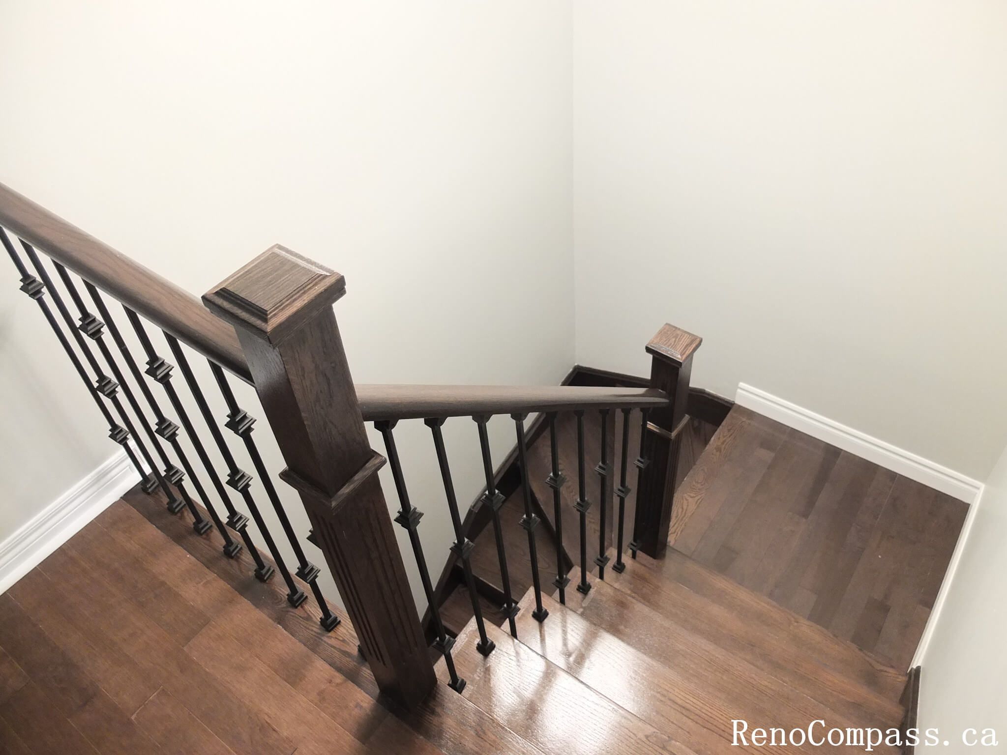 This Richmond Hill interior renovation showcases a modern staircase upgrade featuring dark hardwood flooring paired with custom black iron railings and solid wood posts. Completed by an experienced Toronto renovation company, the design enhances safety, durability, and visual elegance while creating a cohesive connection between floors. The refined railing details and warm wood tones add a sophisticated architectural element to the home’s interior.