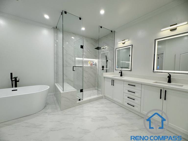 This modern Vaughan bathroom renovation features a clean and elegant layout with a double vanity, quartz countertop, and sleek black fixtures. A frameless glass shower with large-format marble-look tiles creates a spacious and luxurious feel, while the freestanding bathtub adds a spa-like touch. Completed by a professional Toronto Renovation Company, this bathroom design focuses on functionality, durability, and timeless modern aesthetics.