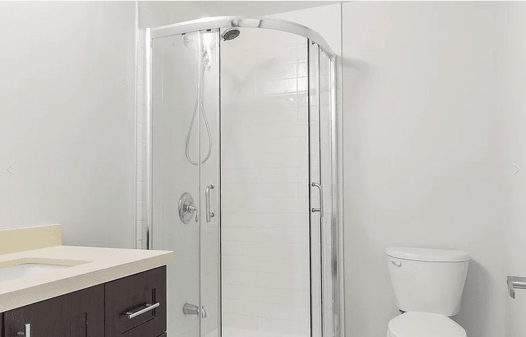 A sleek, contemporary bathroom from our Vaughan full house renovation featuring a frameless glass shower, modern vanity with clean lines, and neutral color palette. Designed for both comfort and elegance, this bathroom showcases efficient use of space and high-quality finishes.